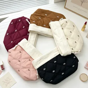 Detailed view of quilted bow drawstring makeup bags in multiple colors