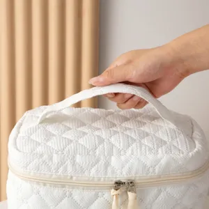 Primer plano de un neceser acolchado blanco con asa resistente para facilitar el transporte
