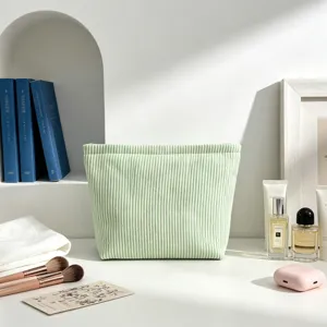 Vue rapprochée d'une trousse à maquillage en seersucker à rayures vert clair nette