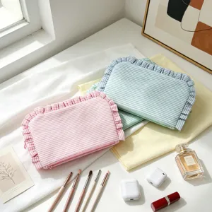 Detail view of colorful seersucker striped makeup pouches with ruffled edges and zippers