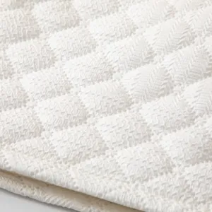 Primer plano macro de tela con textura blanca, patrón de diamantes y tejido detallado