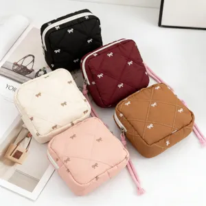 Detailed view of quilted bow mini makeup bags in various pastel and neutral colors