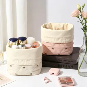 Detailed macro shot of quilted cotton drawstring cosmetic bags with embroidered bows