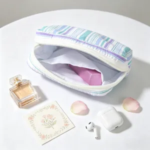 Detail showing open striped seersucker storage pouch with internal pocket and soft texture