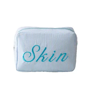 Trousse de maquillage en seersucker à rayures bleues avec broderie Skin et fermeture éclair