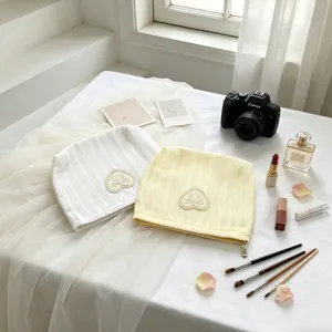 Detail of cream and yellow knitted cosmetic bags with elegant lace heart and bow accents