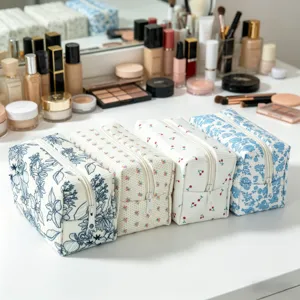 Set aus vier verschiedenen floralen Cord-Kosmetikbeuteln auf einem weißen Frisiertisch