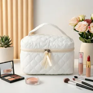 Elegante neceser acolchado blanco en un sofisticado entorno de tocador con cosméticos