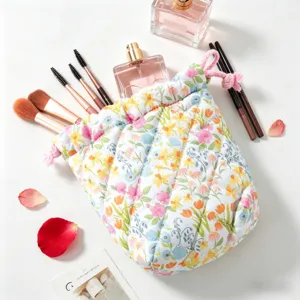 Detailed close-up of a floral quilted drawstring cosmetic bag with makeup accessories
