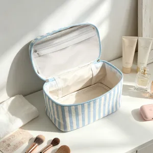Vue détaillée de la trousse de maquillage en seersucker à rayures bleues ouverte