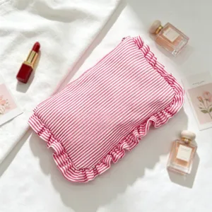 Detail van rood-witte seersucker gestreepte toilettas met ruches aan randen