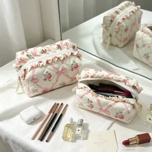 Detailansicht gesteppter Make-up-Taschen mit Blumenmuster und Rüschen