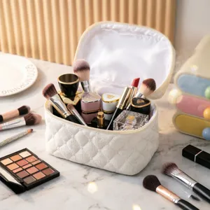 Vista detallada de bolsa de maquillaje blanca acolchada con diversos cosméticos