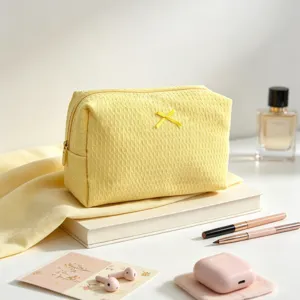 Primer plano de un neceser amarillo con textura de gofre y un lazo