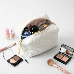 Detalle del neceser de maquillaje blanco con relieve y artículos de belleza.