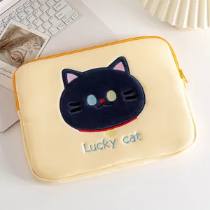 Detailopname van de schattige zwarte kattenborduurwerk op een crème laptoptas.