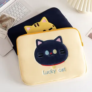 Detail van het schattige lucky cat borduurwerk op een zachte laptoptas hoes