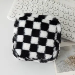Primo piano di una borsa per trucchi in peluche a scacchi neri e bianchi soffici