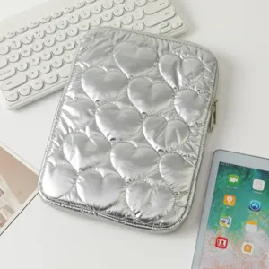 Vista detallada de una funda para tableta acolchada con corazones plateados y suave relleno