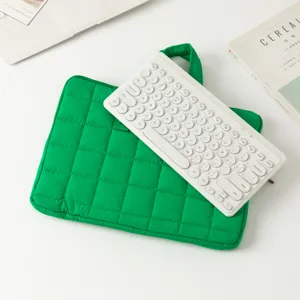 Dettaglio di una custodia per laptop trapuntata verde vibrante con manico