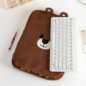 Detailed view of brown plush bear laptop sleeve next to a white computer keyboard