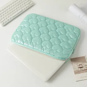 Detalle de funda para portátil verde menta con diseño de corazones acolchados suave.