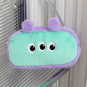 Detailopname van de schattige pluchen monster-etui in muntgroen en paars ontwerp.