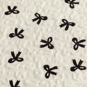 Makroansicht der geknitterten Stofftextur mit schwarzem Schleifendruck auf Laptoptasche