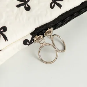 Detailansicht der Metall-Doppelreißverschlüsse an einer Laptop-Tasche mit Schleifen