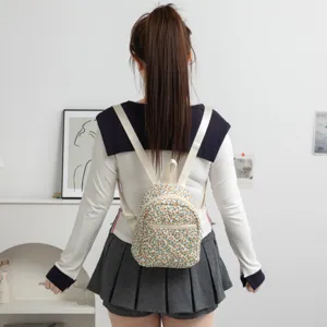 Vista trasera de una mini mochila acolchada con flores llevada con un uniforme.