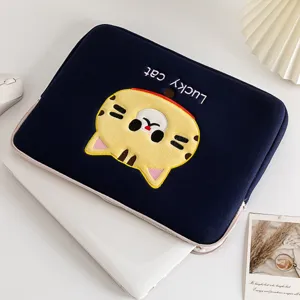 Detailweergave van donkerblauwe laptophoes met schattig geel gelukskat borduursel