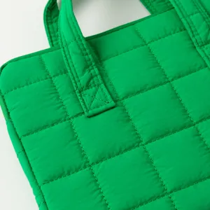 Dettaglio macro della trama e cuciture di una custodia per laptop trapuntata verde