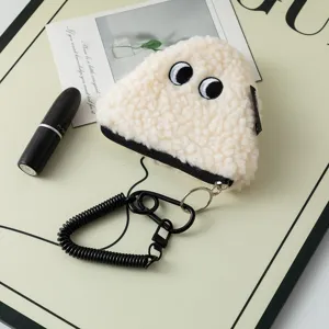 Close-up view of cute plush rice ball coin purse featuring black spring coil keychain