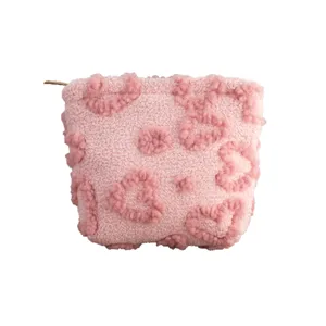 Cute soft pink plush cosmetic bag with embossed heart patterns and zipper for travel