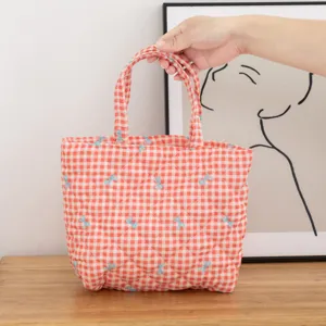 Bolsa de cosméticos acolchada a cuadros rojos con patrones de lazos azules y asa superior