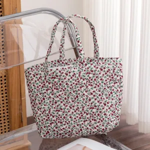 Vista detallada del bolso tote de algodón acolchado floral con asas de tela
