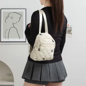 Vista detallada en modelo de la mochila acolchada crema con bordados de lazos!!!