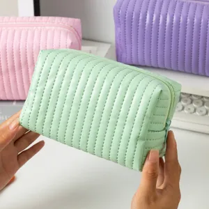 Detailopname van een mintgroene gewatteerde PU-cosmetische tas voor op reis gebruik.