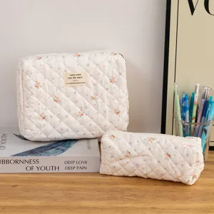 Detailed view of quilted cotton cosmetic bags with a delicate floral print and patch label