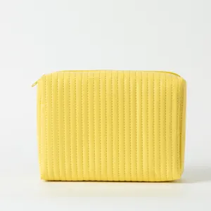 Detailansicht einer leuchtend gelben gesteppten Kosmetiktasche mit Steppnähten