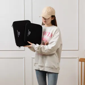Model holding black laptop and tablet sleeves in two sizes for 11 inch iPad and 13.3 inch laptop