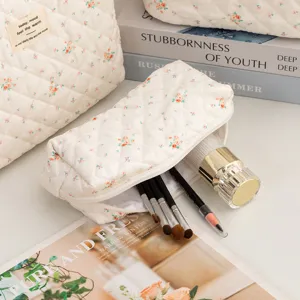 Macro detail view of floral quilted cotton makeup bag with brushes inside for travel