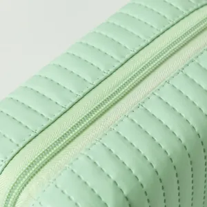 Macro detail van een mintgroene PU-lederen cosmetische tas met bijpassende rits