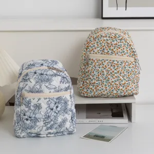 Primer plano detallado de dos mochilas acolchadas con estampados florales para niñas en azul