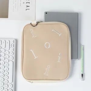 Top view of a beige protective laptop sleeve for iPad 11 and 13.3 inch MacBook with props