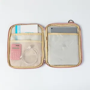Internal view of a pink tablet organizer showing compartments for iPad, cables, and notebook.