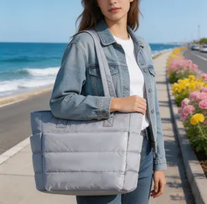 Détail d'un mannequin portant un grand sac cabas matelassé gris clair pour le yoga en extérieur