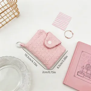 Abmessungen der rosa gefalteten Mini-Geldbörse mit Lifestyle-Requisiten und Clip