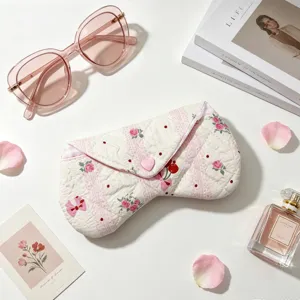 Detalle del estuche de tela acolchada para gafas con botón de corazón y rosas