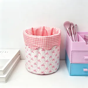 Detail of pink quilted fabric storage basket with bow pattern on desk
